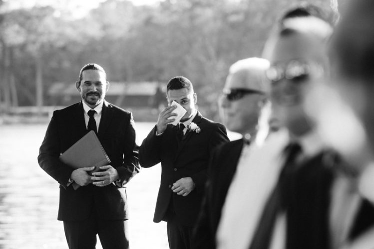 Groom reacts to bride as she walks down the aisle